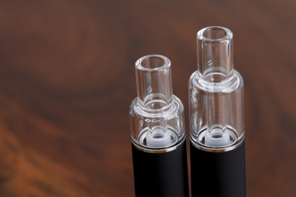 Close-up of the cotton-free, all-glass tanks and mouthpieces on the black wholesale Traveler Extreme All Glass Bucket AIO units, available in 0.5ml and 1ml sizes.
