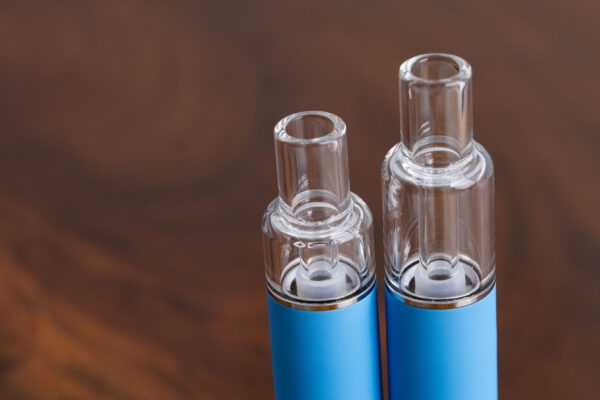 Close-up of the O2VAPE Traveler Extreme All Glass Bucket AIO’s all-glass mouthpieces and tanks in 0.5ml and 1ml formats, showcasing cotton-free airflow design and clean oil visibility.